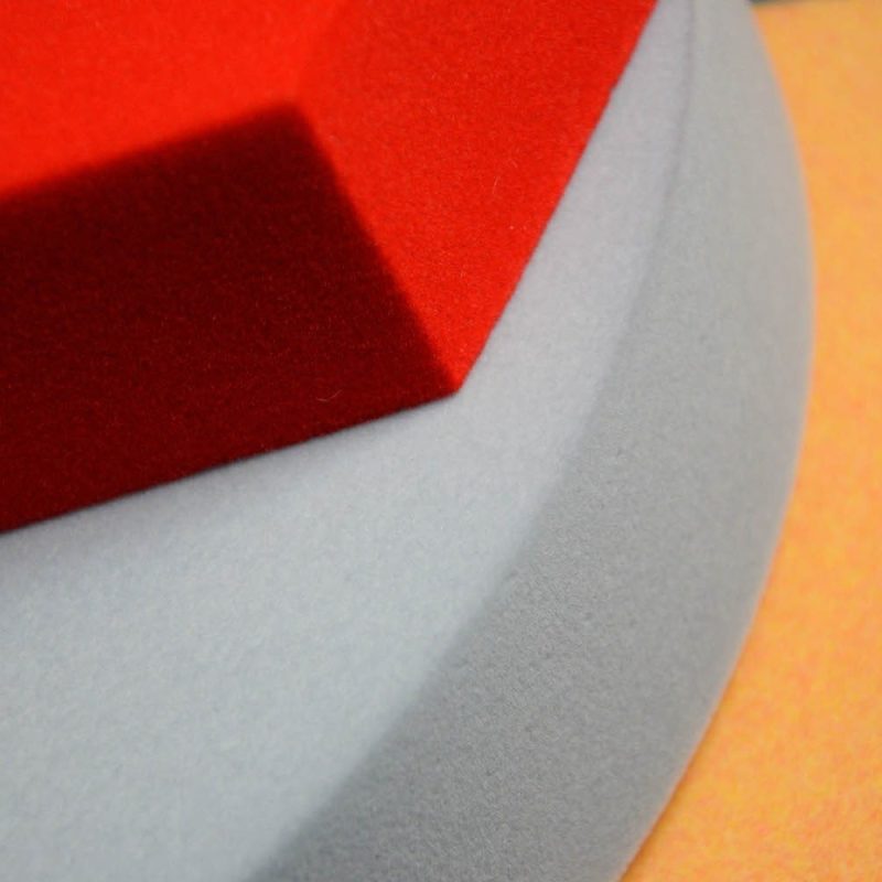 Nahaufnahme der beflockten Oberfläche der Foamly-Paneele in drei Farben - Rot, Grau und Orange